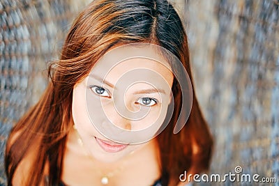 Portrait of young beautiful girl sitting on rattan hammock, blurry background Stock Photo