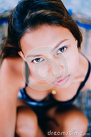 Portrait of young beautiful girl sitting on rattan hammock, blurry background Stock Photo