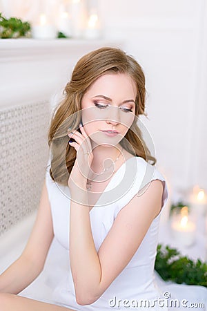 Portrait of a young shy girl in a clean dress, her hand touching her face gently. Gorgeous young brunette woman with in a spa and Stock Photo