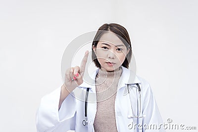 Portrait of a young and skilled doctor, medical student, intern posing with one finger up, scolding someone. Isolated on a white Stock Photo