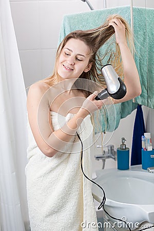 Portrait of young smiling woman drying long hair after having bath Stock Photo