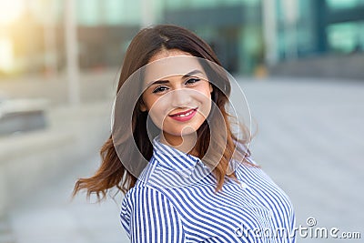 Portrait of young smiling woman outdoors with sunligth flare Stock Photo