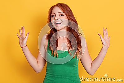 Portrait of young stunning model with bright red hair, pretty woman in fashionable green shirt, posing with excited facial Stock Photo