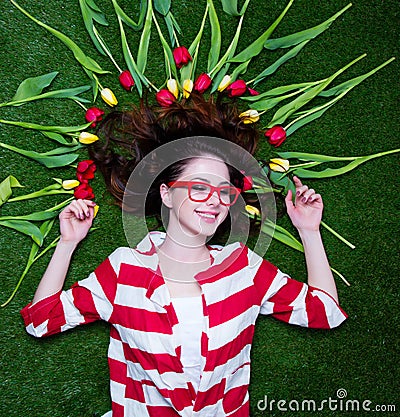 Portrait of a young styled redhead woman tulips around and glass Stock Photo