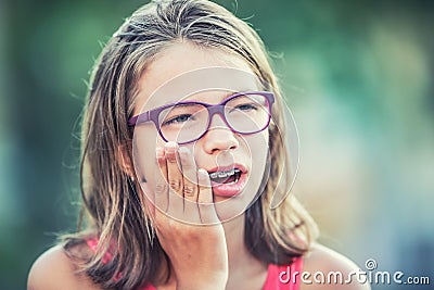 Portrait of young teen girl with toothache. Girl with dental braces and glasses Stock Photo