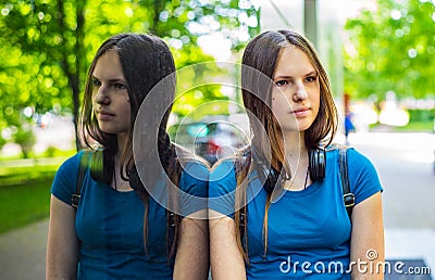 Portrait of young teenager brunette girl with long hair. an urban environment of a street warehouse, woman and reflection in the g Stock Photo