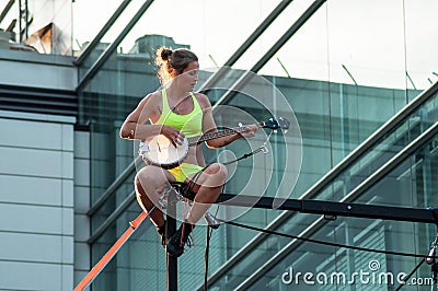 Portrait of a young woman on balance with banjo for an outdoor aerobatics show in Mulhouse Editorial Stock Photo