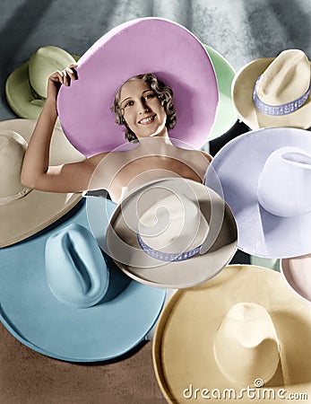 Portrait of a young woman covered with hats Stock Photo