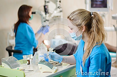 Portrait of young woman dentist assistant holding dental tool Stock Photo