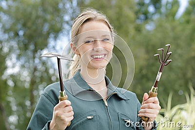 Portrait young woman gardener with gardening tools outdoors Stock Photo
