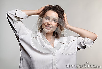 Portrait of young woman on gray background. Female posing in milky white corduroy shirt Stock Photo