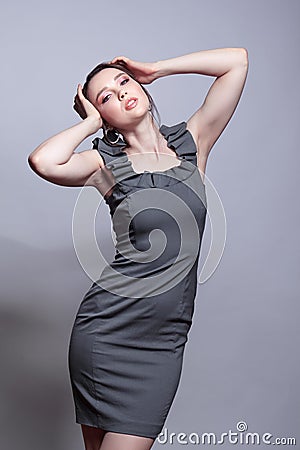 Portrait of young woman in gray dress on grÐµy background Stock Photo