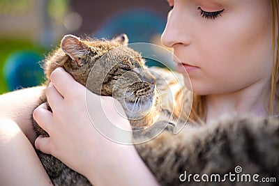 Portrait of young woman holding a cat in her arms. Pretty lady holding little sweet, adorable kitten Stock Photo