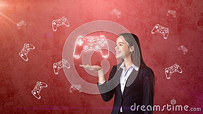 Portrait of young woman holding gamer`s joystick on the open hand palm, over drawn studio background. Business concept. Stock Photo