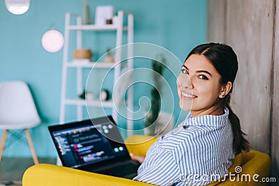 Portrait of young woman mobile developer with laptop, writes program code on a computer, programmer work Stock Photo