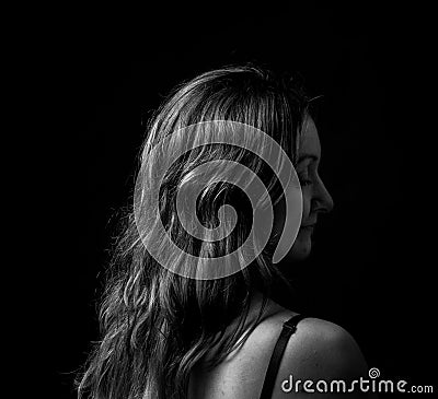 Portrait of young woman, no make up, low key, brown dark hair, no retouch making expressions Stock Photo