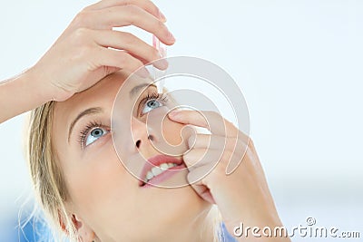 Portrait of young woman putting eye drops Stock Photo