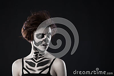 Portrait of young woman with scared halloween makeup on black background Stock Photo