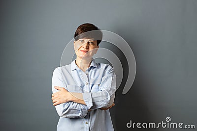 Portrait of a young woman with a short haircut on gray blank background. Human emotions facial expression happiness joy Stock Photo