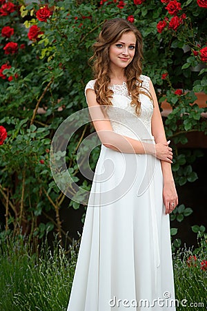 Portrait of young woman in the spring time. Almond flowers blossoms. Girl dressed in white like a bride. rose Garden Stock Photo