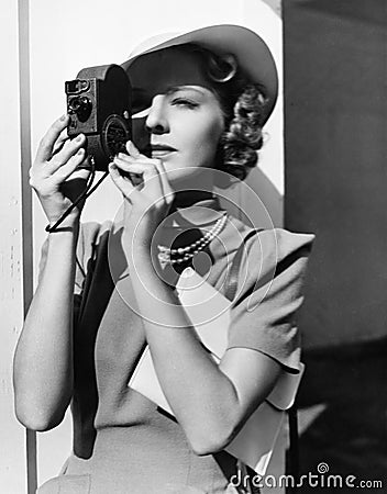 Portrait of a young woman taking a picture with a camera Stock Photo