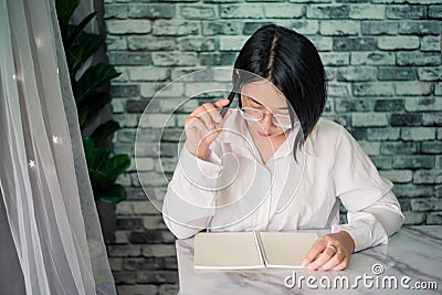 Portrait of young woman thinking while serious working at home with laptop on desk Stock Photo