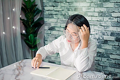Portrait of young woman thinking while serious working at home with laptop on desk Stock Photo