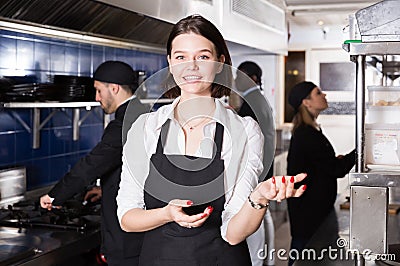 Portrait of young woman waiter who is satisfied of work on kitchen Stock Photo