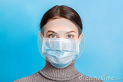 Portrait of young woman wearing medical mask at blue background. Protect your health. concept Stock Photo