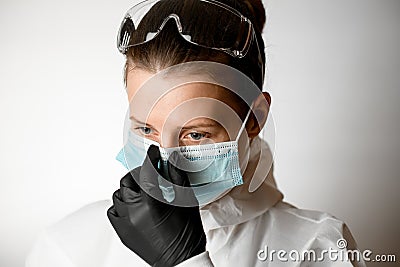 Portrait of young woman which regulate medical mask on her face Stock Photo