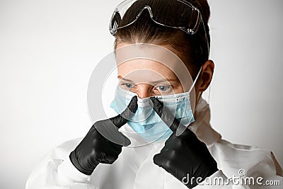 Portrait of young woman which regulate medical mask with her fingers Stock Photo