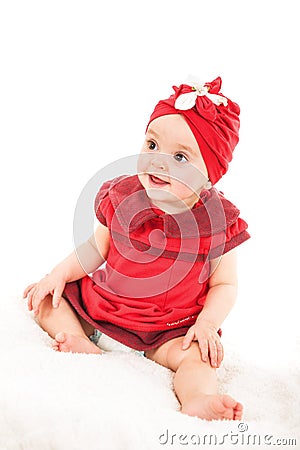 Portrait of young 1 year old baby girl in red dress with red hat on her head looking away Stock Photo