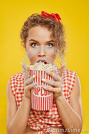 Portrait of ypung shocked girl holding bucket of popcorn Stock Photo