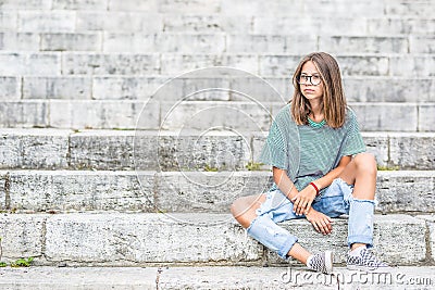 Portraito of young girl in a free modern outfit from jeans with holes Stock Photo