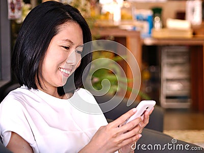 Portraits of Asian woman looking to her white smartphone. Stock Photo