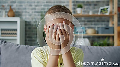 Portret van een schattige jongen die verstopt zit te spelen en naar de ogen te kijken met handen die lachen stock videobeelden Portret van een schattige jongen die verstopt zit te spelen en naar de ogen te kijken met handen die lachen stock videobeelden