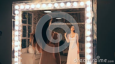 Portret van elegant meisje in avondjurk het stellen voor een spiegel met de lichten in de kleedkamer Brunette met stock footage Portret van elegant meisje in avondjurk het stellen voor een spiegel met de lichten in de kleedkamer Brunette met stock footage
