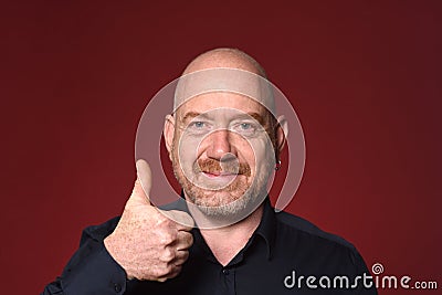 Portriat of a man with thumbs up on red background Stock Photo