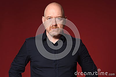 Portriat of serious bald man on red background Stock Photo