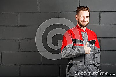 Portriat of smiling man wearing overalls near brick wall Stock Photo