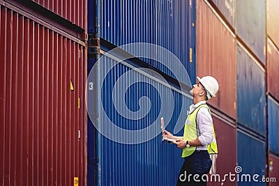 Portrait worker engineer hold a laptop and walking to checking the containers box Stock Photo