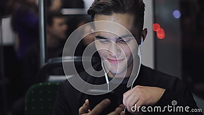 Porträt von den jungen headsome Männern in den Kopfhörern hörend Musik und am Handy grasend transportieren öffentlich stadt stock footage Porträt von den jungen headsome Männern in den Kopfhörern hörend Musik und am Handy grasend transportieren öffentlich stadt stock footage