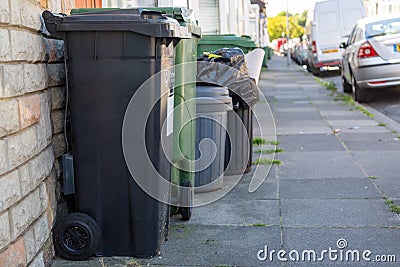 06/25/2020 Portsmouth, Hampshire, UK black wheelie bins and green recycling bins outside homes ready for collection Editorial Stock Photo