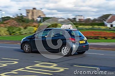 A driving instructors car moving along the road at speed with the learner driver driving Editorial Stock Photo