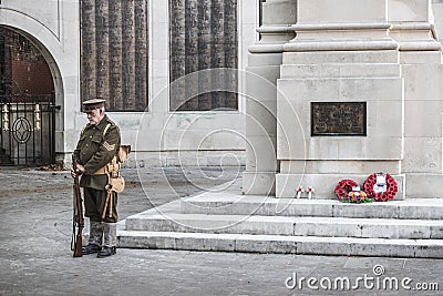 09/14/2019 Portsmouth, Hampshire, UK A man in World war one soldiers uniform standing next to a British war memorial with red Editorial Stock Photo