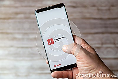 02-05-2021 Portsmouth, Hampshire, UK A Mobile phone or cell phone being held showing the Adobe acrobat reader app open on screen Editorial Stock Photo