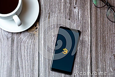 02/10/2021 Portsmouth, Hampshire, UK A mobile phone or cell phone laid on a wooden table with the Coinbase crypto currency app Editorial Stock Photo