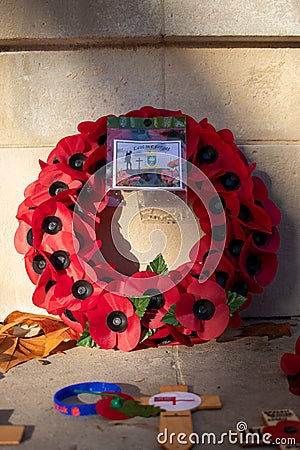 11/11/2019 Portsmouth, Hampshire, UK A red poppy wreath laid in front of a war memorial on remembrance day Editorial Stock Photo