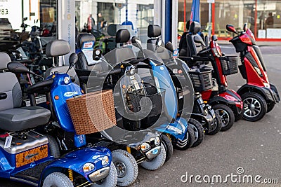 02/06/2020 Portsmouth, Hampshire, UK A row of mobility scooters or disability scooters outside a shop on sale Editorial Stock Photo