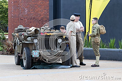 Three men in authentic world war two military uniforms next to an american army jeep from the Editorial Stock Photo